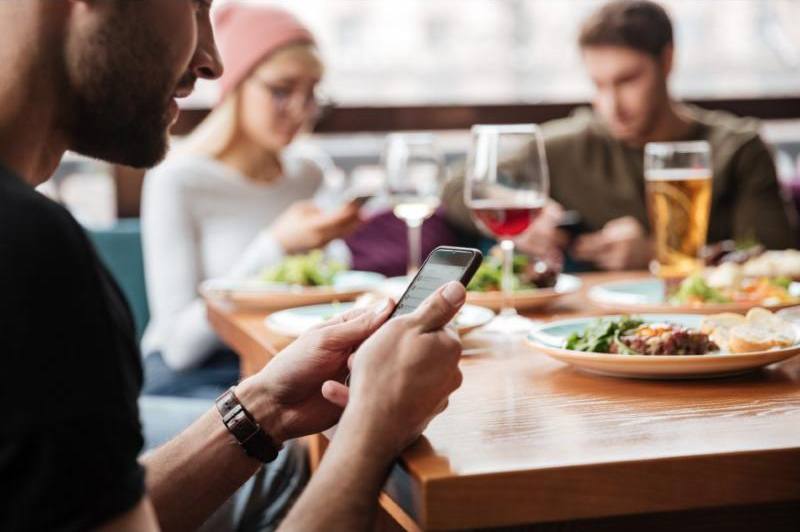 Clientes pidiendo desde el móvil en la mesa